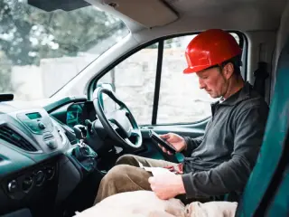 man sat in vehicle on phone
